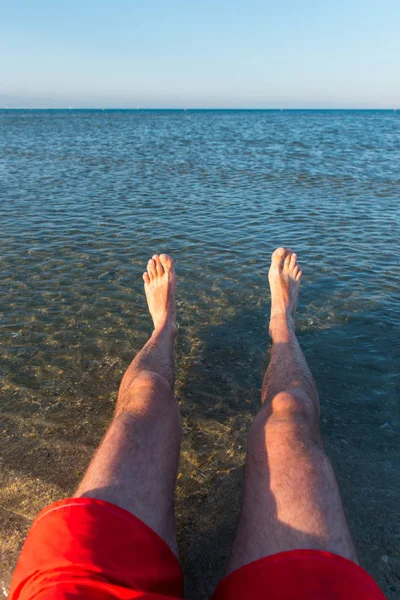 Sea waves washing man's feet — Stock Photo, Image