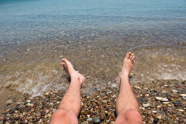 Sea waves washing man's feet — Stock Photo, Image