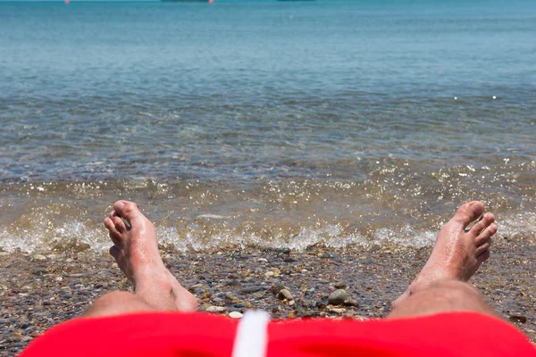 Vagues de mer lavant les pieds de l'homme — Photo