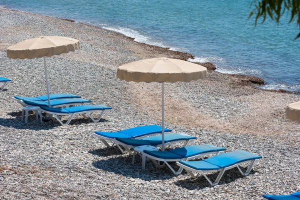 Sonnenliegen und Sonnenschirme am Strand — Stockfoto