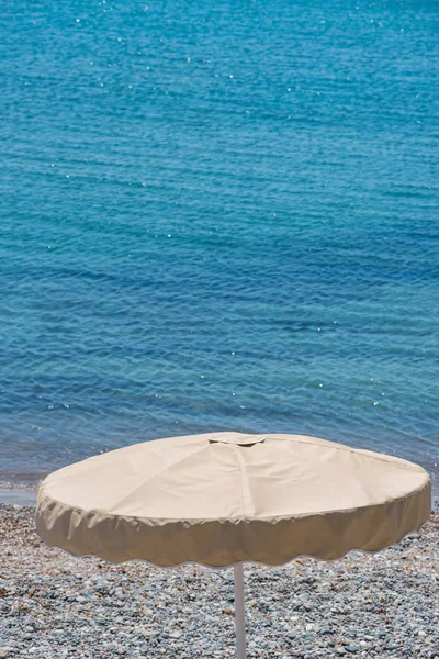 Sun umbrella on the beach, sea in the background — Stock Photo, Image