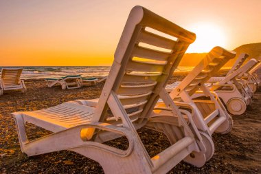 Gün batımında kumsal beyaz şezlong