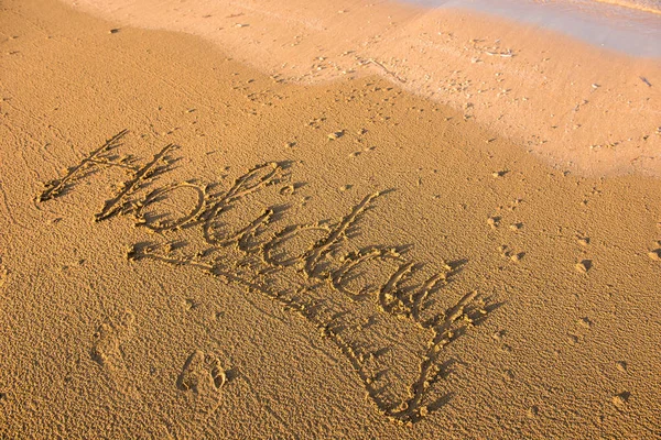 Parola di vacanza scritta nella sabbia — Foto Stock