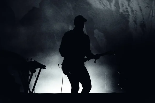 Silhueta de um guitarrista em luzes de palco — Fotografia de Stock