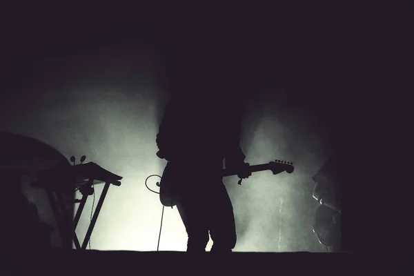 Guitarrista tocando ao vivo em sua guitarra em luzes de palco — Fotografia de Stock
