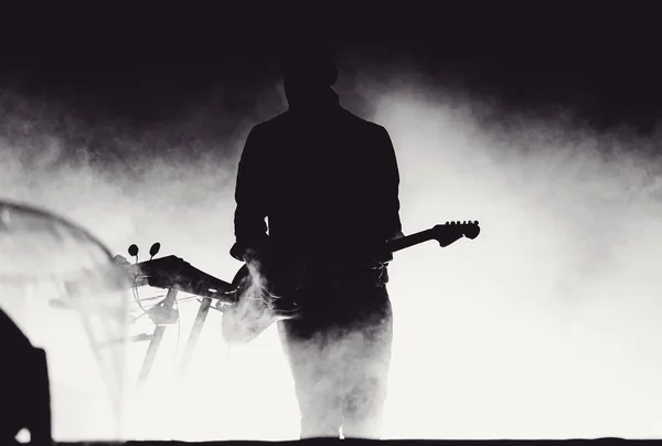 Guitariste jouant en direct dans les lumières de la scène — Photo