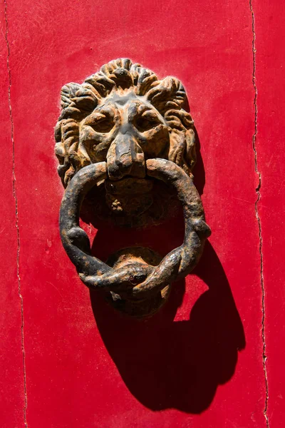 老生锈的铁狮子头门环上一扇红色的门 — 图库照片