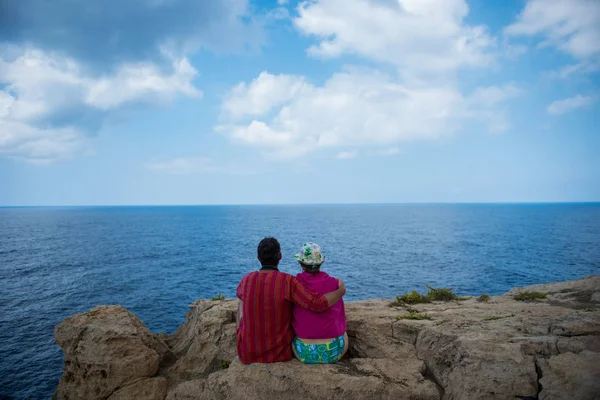 Ρομαντικό ζευγάρι κάθεται σε ένα βράχο και admirig πολύ καλό seascap — Φωτογραφία Αρχείου
