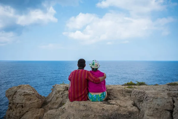 Romantik Çift cliff ve admirig harika seascap üzerinde oturan