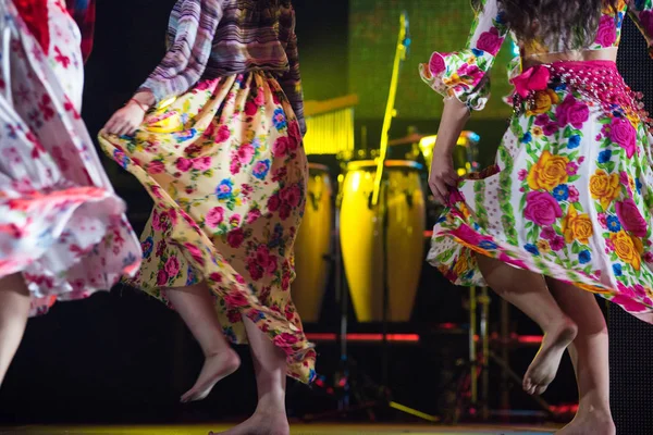 Молодая танцовщица босиком в цыганском платье танцует на сцене — стоковое фото