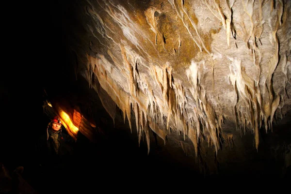 Spelunker admirando estalactitas en una cueva — Foto de Stock
