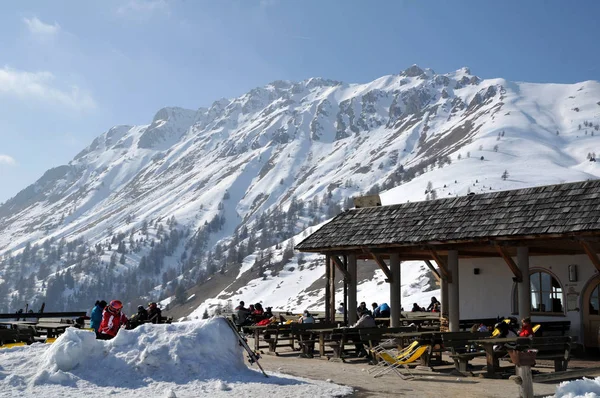 Esquiadores tomando el sol al aire libre en un restaurante en el Dolomit italiano Imagen de stock