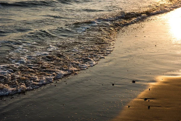 Olas acercándose a la playa de arena durante el atardecer —  Fotos de Stock