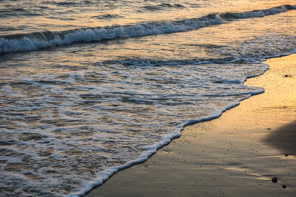 Ondas acercándose a la playa de arena durante el atardecer —  Fotos de Stock