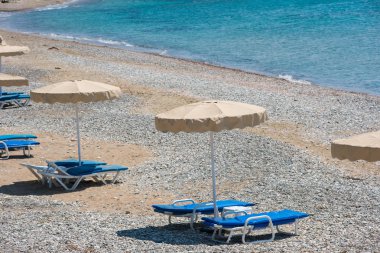 kumsalda güneşlik ve şemsiyeler