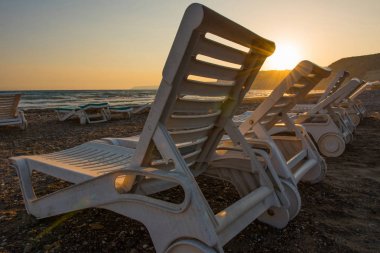 Gün batımında kumsal beyaz şezlong