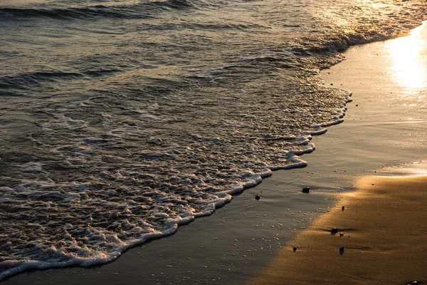 Olas acercándose a la playa de arena durante el atardecer —  Fotos de Stock