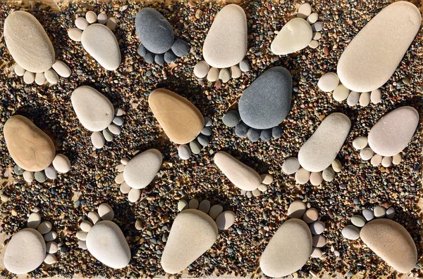 Pedras de seixos dispostas como pegadas na praia — Fotografia de Stock