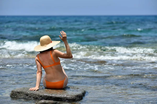 Bikini sexy abbronzante donna rilassante sulla spiaggia con un cappello — Foto Stock