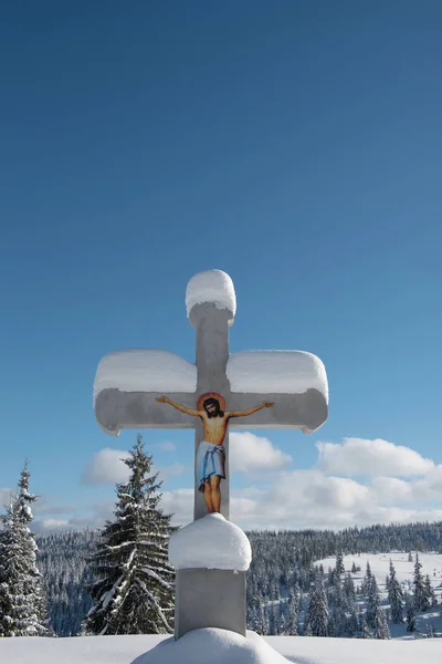 Cruz cubierta de nieve en las montañas — Foto de Stock