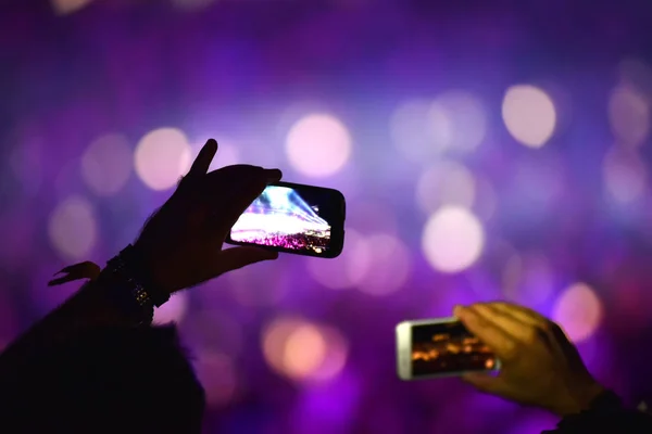 El ele tutuşmalar, akıllı telefonlar ve konser kayıtları. — Stok fotoğraf