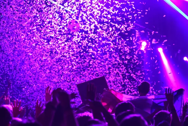 Tłum koncertowy przed jasnymi światłami sceny z konfetti — Zdjęcie stockowe