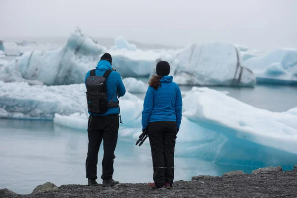 Turisti che ammirano iceberg galleggianti a Jokulsarlon, Islanda — Foto Stock