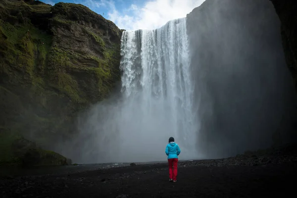 Frau bewundert skogafoss Wasserfall in Island — Stockfoto