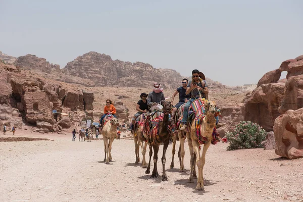 Touristen auf Kamelen in Petra, Jordanien — Stockfoto