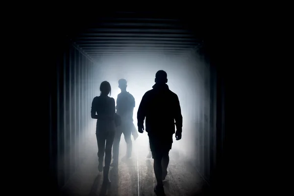 Silhuett av människor i en dimmig tunnel en tunnel — Stockfoto