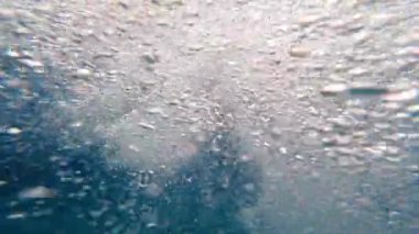 Kadın şnorkelle yüzüyor ve denizde yüzüyor. Sualtı manzarası, suda hava kabarcıkları.