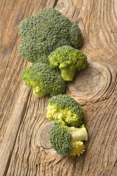 Zelené brokolice organické zeleniny na dřevěné desce — Stock fotografie