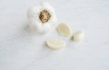 Beyaz arkaplanda taze sarımsak var.