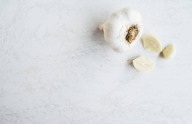 Beyaz arkaplanda taze sarımsak var.