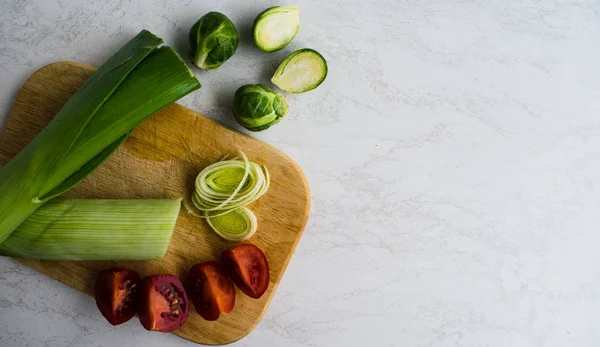 pırasa, domates ahşap tahta üzerinde