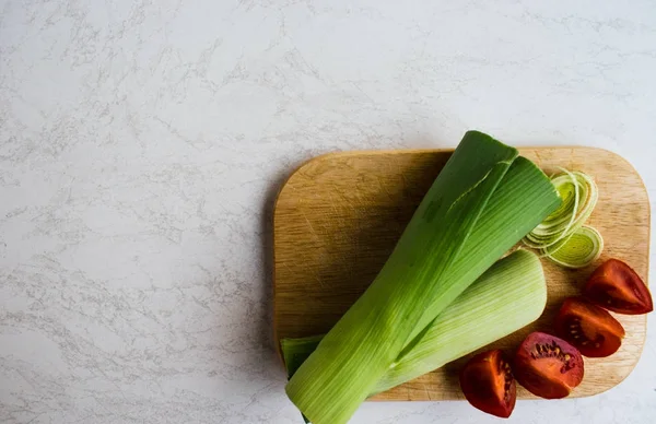 pırasa, domates ahşap tahta üzerinde