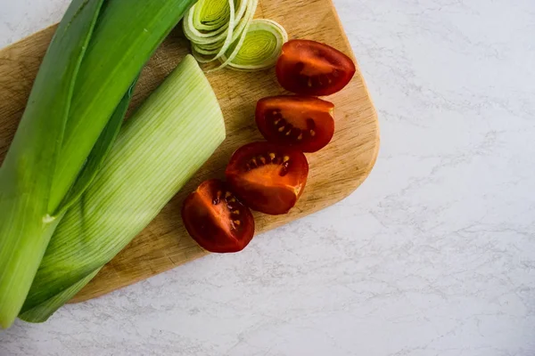 pırasa, domates ahşap tahta üzerinde