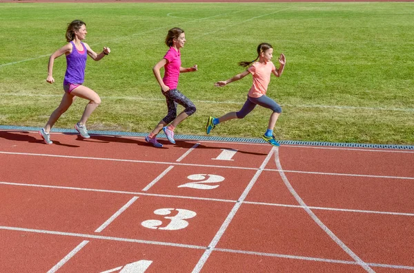 Familienfitness, aktive Mutter und Kinder laufen auf der Stadionbahn, Rückenansicht, Training mit Kindersportkonzept — Stockfoto