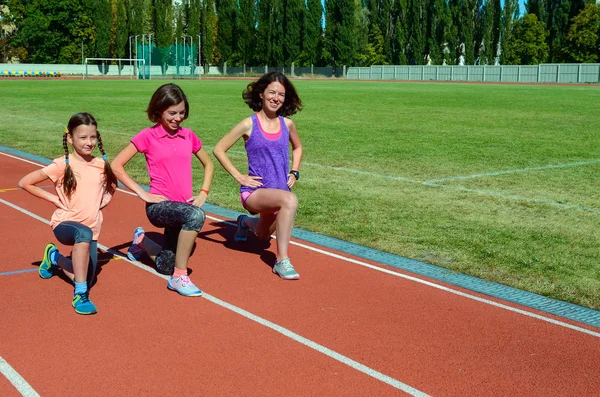Семейный фитнес, тренировки матери и ребенка на стадионе, спорт с детьми — стоковое фото
