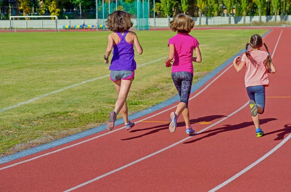 Sport di famiglia, madre e bambini che corrono sulla pista dello stadio, allenamento e concetto di fitness per bambini — Foto Stock