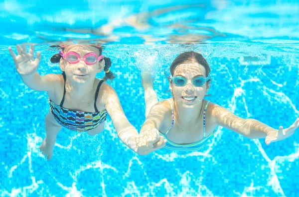 Kinder schwimmen im Pool unter Wasser, fröhliche aktive Mädchen mit Brille haben Spaß, Kindersport im aktiven Familienurlaub — Stockfoto