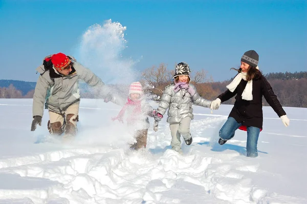 Familia feliz en invierno, divirtiéndose con nieve al aire libre en fin de semana — Foto de Stock