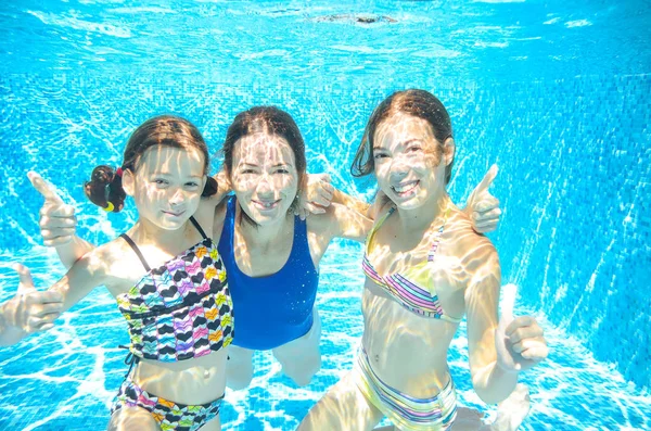 Family swims in pool under water, happy active mother and children have fun, fitness and sport with kids on summer vacation — Stock Photo, Image