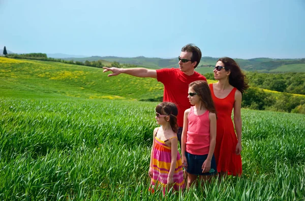 Vacaciones en familia, padres con niños divirtiéndose al aire libre en el campo verde, viajar con niños en Toscana, Italia — Foto de Stock