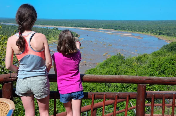 Vacaciones de safari familiar en Sudáfrica, madre e hija mirando la hermosa vista del río, los turistas viajan al parque nacional Kruger —  Fotos de Stock