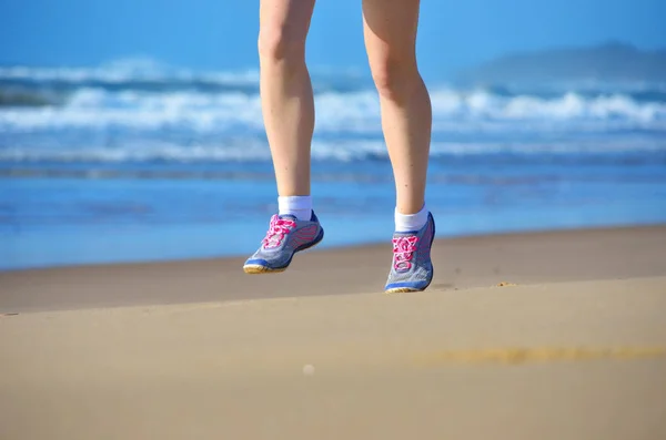 Fitness e corrida na praia, pernas mulher corredor em sapatos na areia perto do mar, estilo de vida saudável e conceito de esporte — Fotografia de Stock