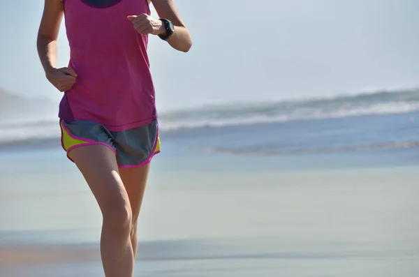 Fitness y correr en la playa, mujer corredor haciendo ejercicio en la arena cerca del mar, estilo de vida saludable y el concepto de deporte —  Fotos de Stock