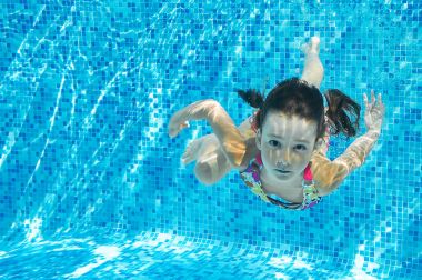 Çocuk havuzunda su altında yüzüyor, mutlu etkin kız dalışlar ve eğlenceli, çocuk fitness ve spor ailecek tatile var.