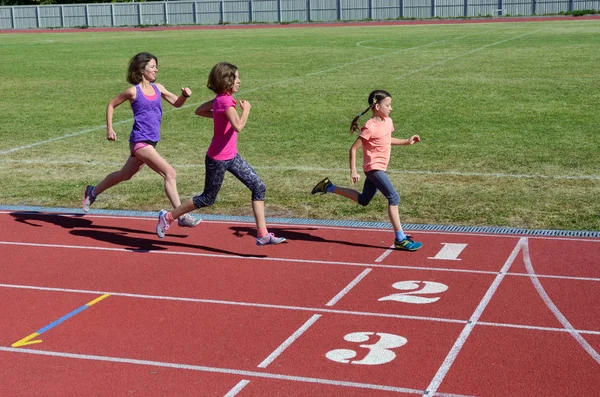 Familj fitness, mamma och barn som springer på stadion spår, träning och barn sport hälsosam livsstil koncept — Stockfoto