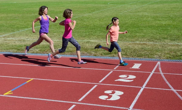 Family fitness, mother and kids running on stadium track, training and children sport healthy lifestyle concept